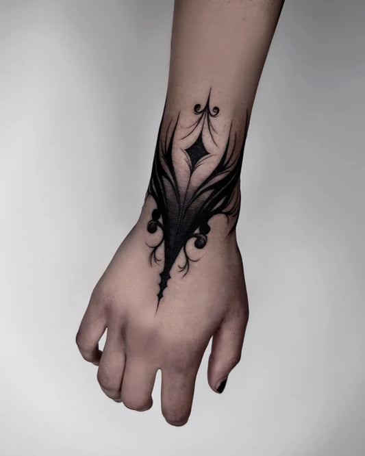 Small Gothic Floral Wing Design Tattoo on Women Wrist by @ghoulish.ink