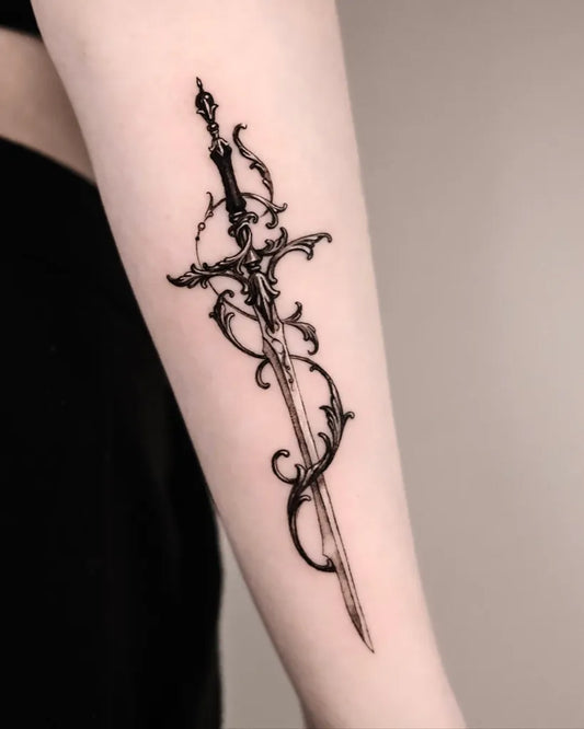 Small Gothic Ornate Sword Tattoo on Women Arm by @auua.tattoo