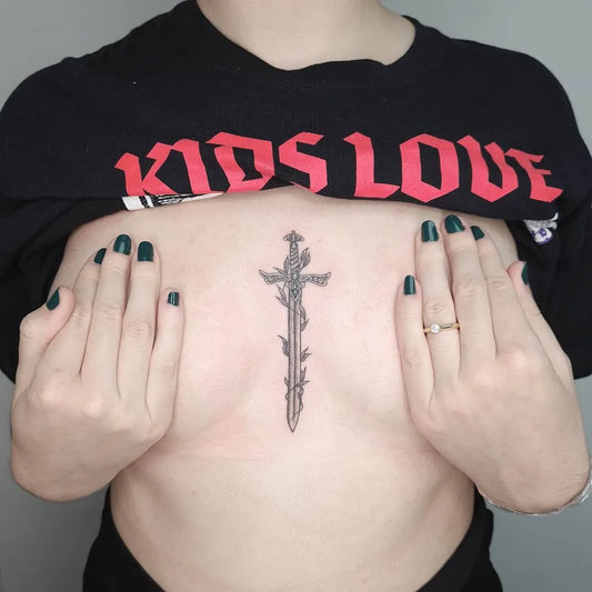 Small Gothic Sword on Women Sternum Tattoo by @ninareymondtattoo