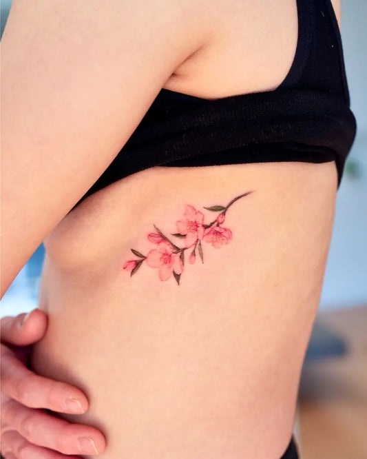 Small Illustrative Cherry Blossom Branch on Women Rib Tattoo by @tattooist_gaon