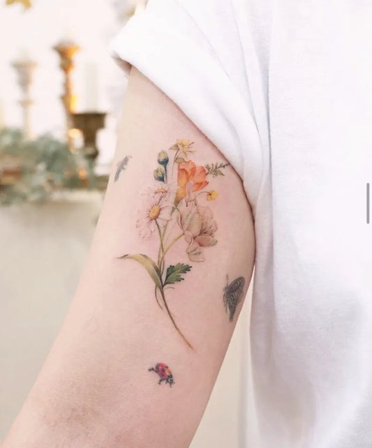 Small Illustrative Daisy and Ladybug Tattoo on Women Arm by @tattooist.haneul