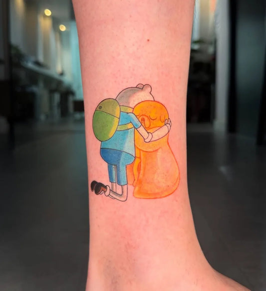 Small Illustrative Finn and Jake Hugging Cartoon Tattoo on Women Leg by @ana666tattoo