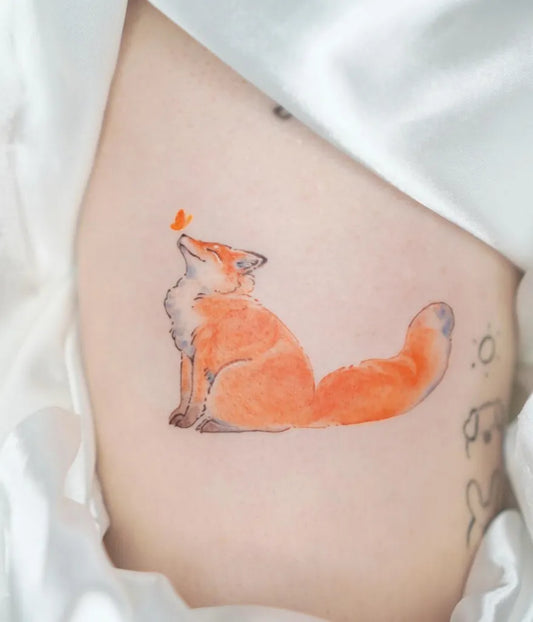 Small Illustrative Fox and Butterfly Tattoo on Women Rib by @o.nyx.tattoo