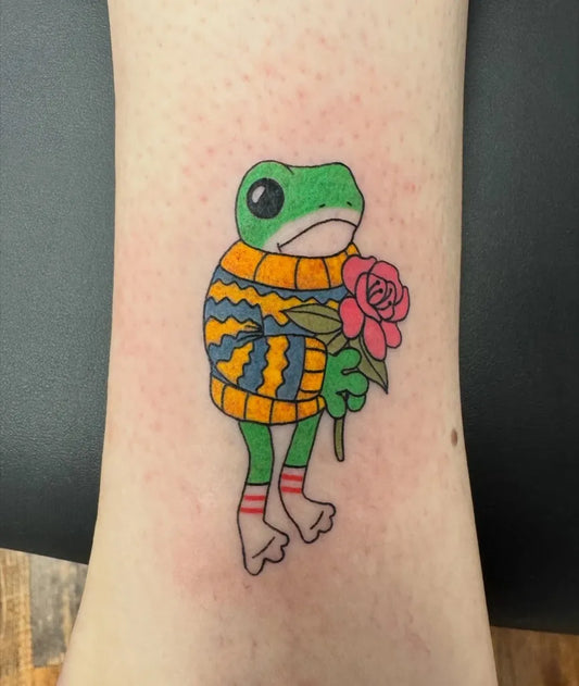 Small Illustrative Frog with Sweater and Rose Tattoo on Women Leg by @chrischampiontattoo