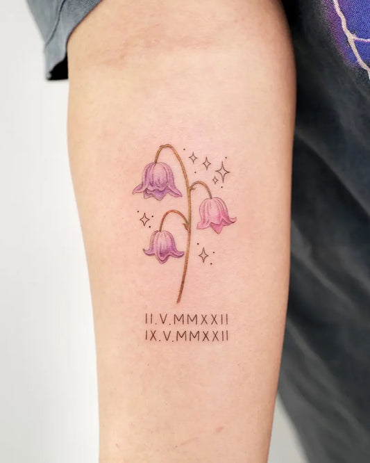Small Illustrative Lily of the Valley with Stars and Roman Numerals on Women Arm Tattoo by @tattooist_dal