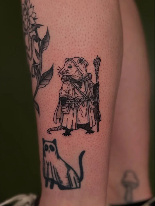Small Illustrative Opossum Wizard and Ghost Cat Tattoo on Women Leg by @tapiotats