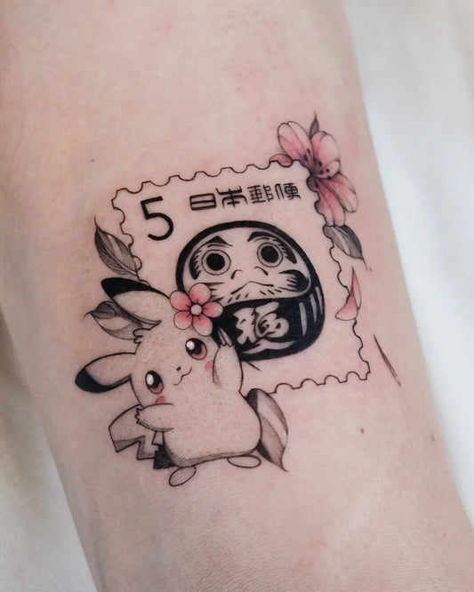 Small Illustrative Pikachu Daruma Stamp Tattoo on Women Arm by @yodatattoos