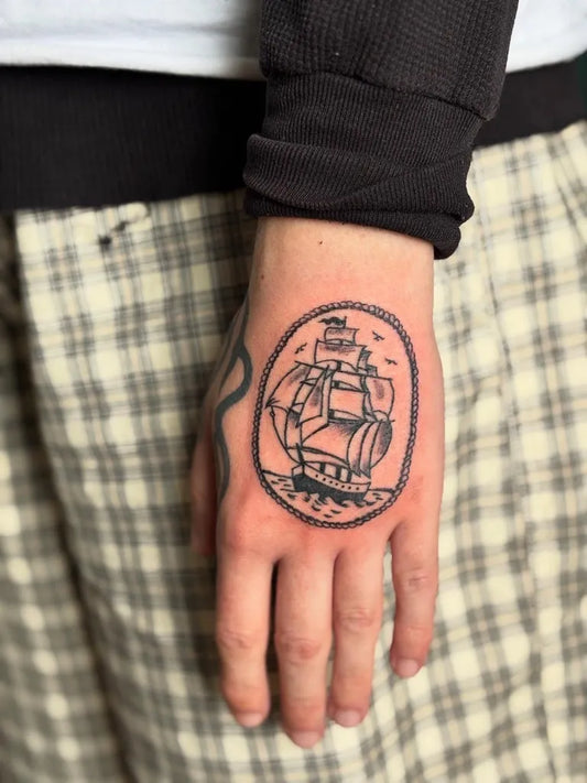 Small Illustrative Ship Tattoo on Men Wrist by @snow.pokes