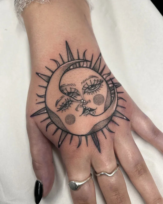 Small Illustrative Sun and Moon with Face on Women Hand Tattoo by @megrobertstattoo