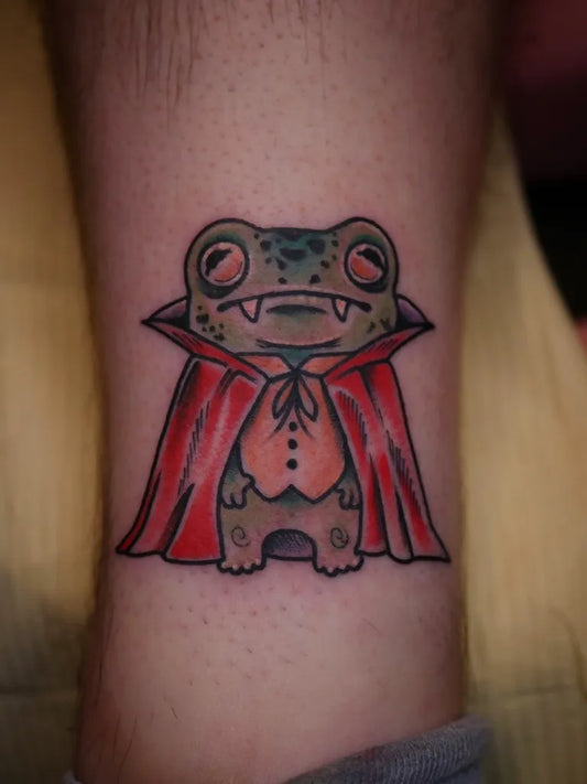 Small Illustrative Vampire Frog Tattoo on Men Leg by @patcrump