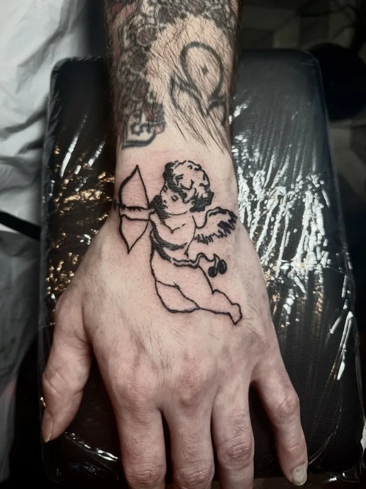 Small Linework Cherub Tattoo on Men Hand by @gray.space.ink