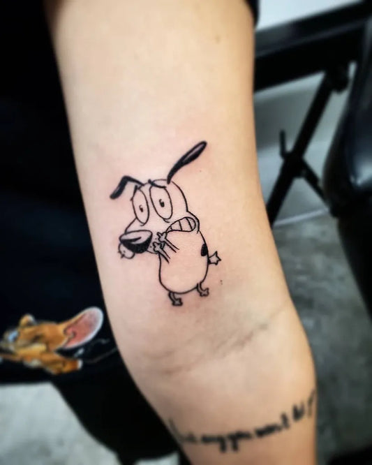 Small Linework Courage the Cowardly Dog Tattoo on Women Bicep by @tiagotargaca