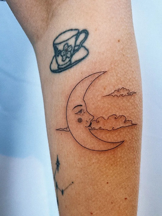 Small Linework Crescent Moon Teacup Tattoo on Women Arm by @sharp_pokes