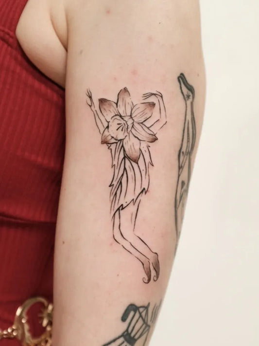Small Linework Daffodil Fairy Tattoo on Women Arm by @sophiewiegersma