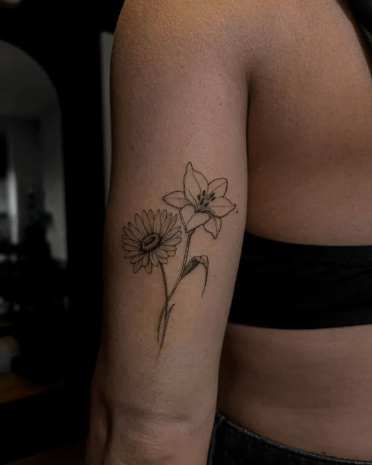 Small Linework Daisy and Lily Tattoo on Women Arm by @hannesmit
