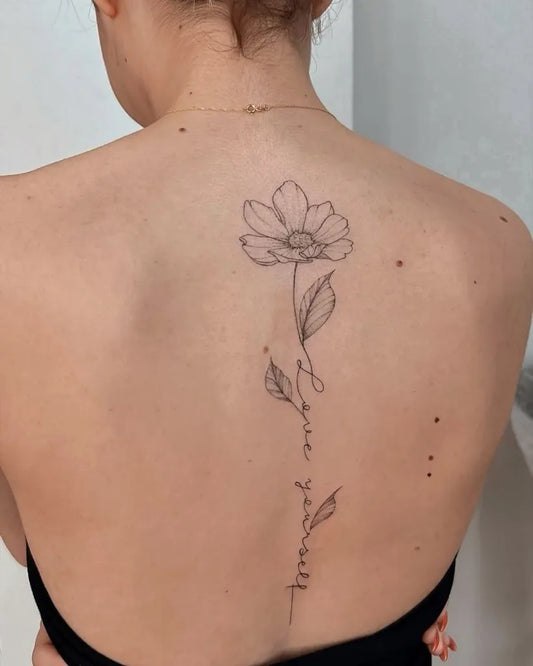 Small Linework Daisy and Love Yourself on Women Spine Tattoo by @tattoobullstudio