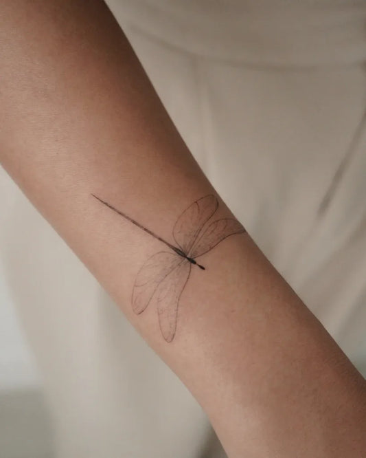 Small Linework Dragonfly on Women Arm Tattoo by @tattoowithkay