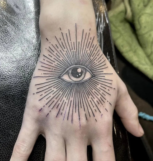 Small Linework Eye with Rays on Women Wrist Tattoo by @redrumtattooparlour