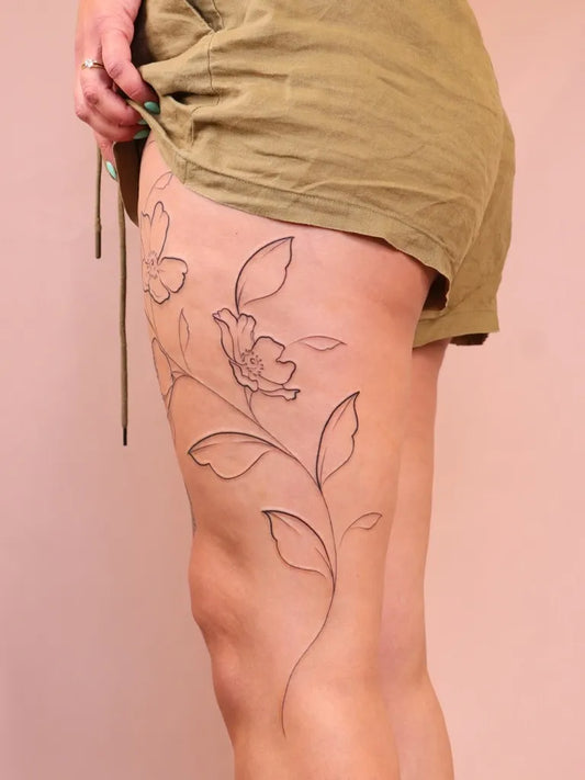 Small Linework Flower Vine on Women Thigh Tattoo by @zaya