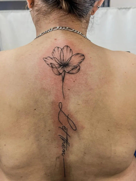 Small Linework Flower with Let Them on Women Back Tattoo by @relentless_ink_tattoo