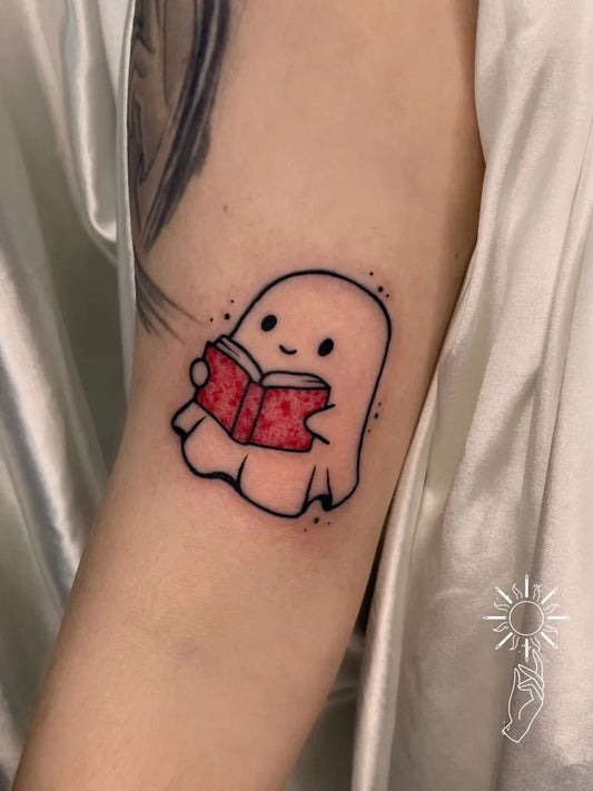 Small Linework Ghost Reading Book Tattoo on Women Arm by @mercadora_oficial