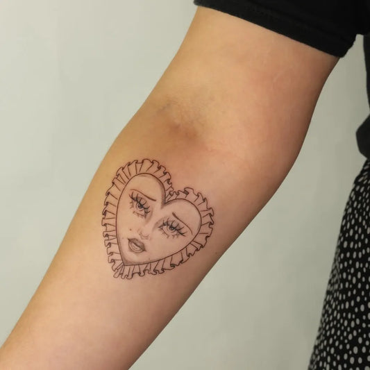 Small Linework Heart Face on Women Arm Tattoo by @evadarlingtattoos