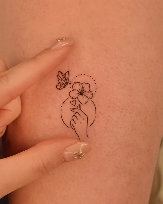Small Linework Hibiscus Flower Butterfly Hand on Women Shoulder Tattoo by @tinytattooinc
