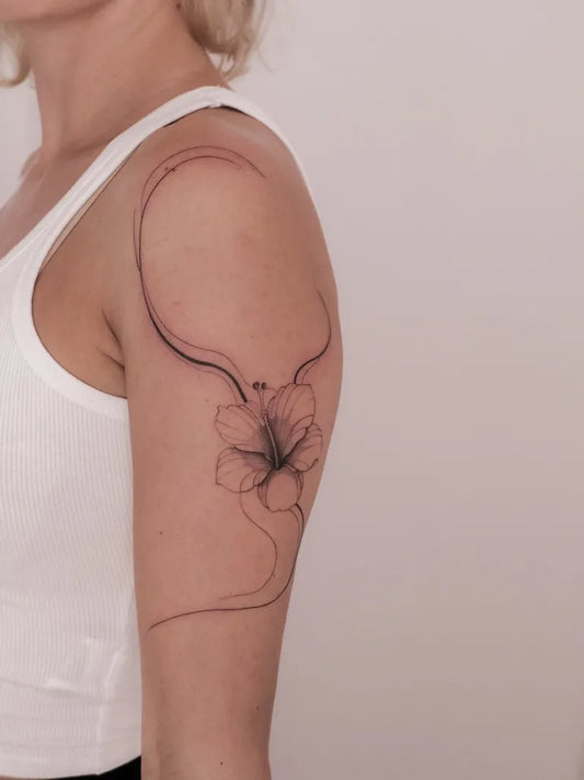 Small Linework Hibiscus Flower on Women Shoulder Tattoo by @kwiatek_tattoo