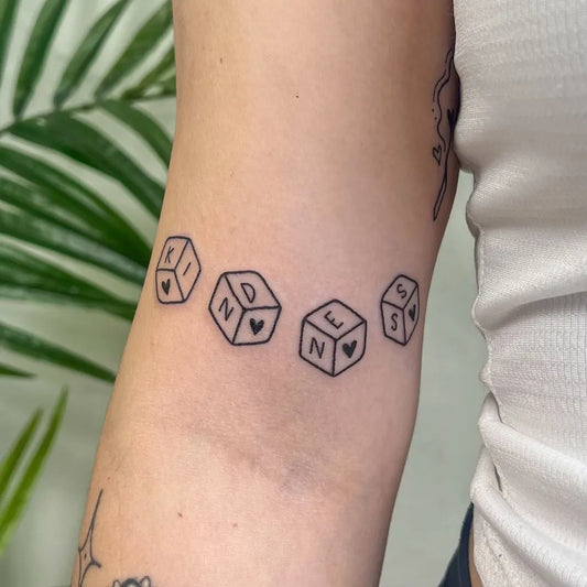 Small Linework KINDNESSDice Tattoo on Women Arm by @jadehazetattoo