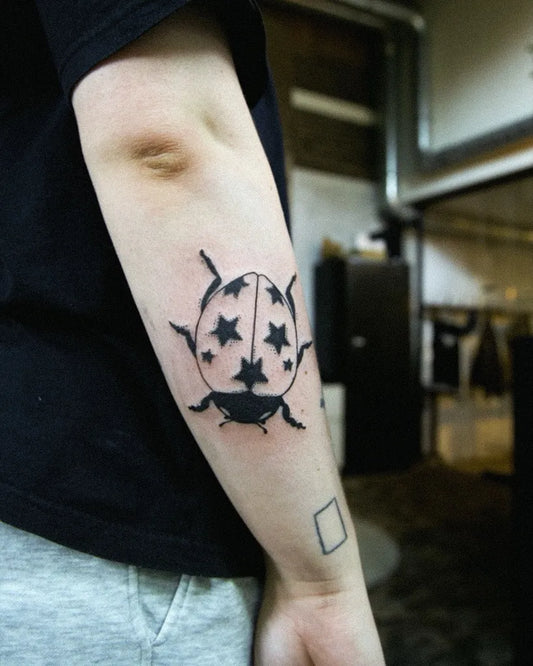 Small Linework Ladybug Tattoo on Men Arm by @codetattoos