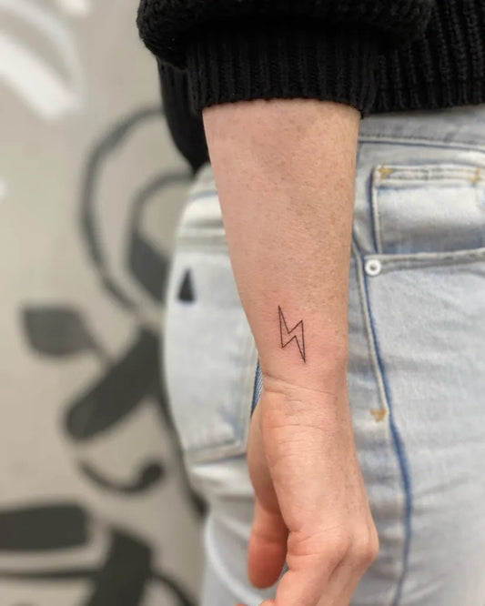 Small Linework Lightning Bolt Tattoo on Women Wrist by @inkypalette.tattoos