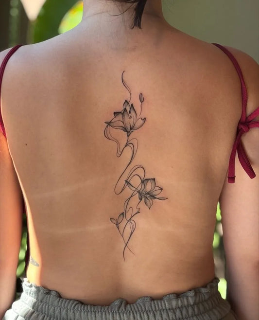 Small Linework Lotus Vine on Women Back Tattoo by @manchestertattoostudio