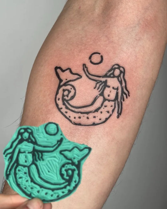Small Linework Mermaid and Sun Tattoo on Women Arm by @hallelmeltzer