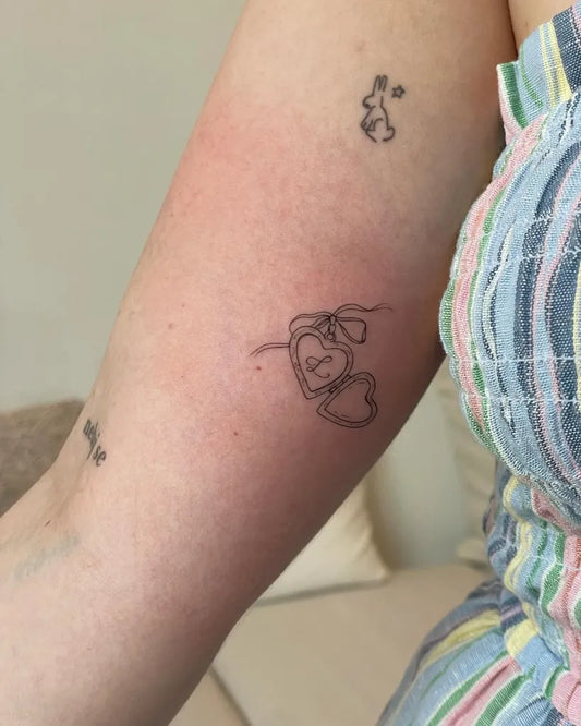 Small Linework Open Locket with Initials Tattoo on Women Arm by @vivien.veight