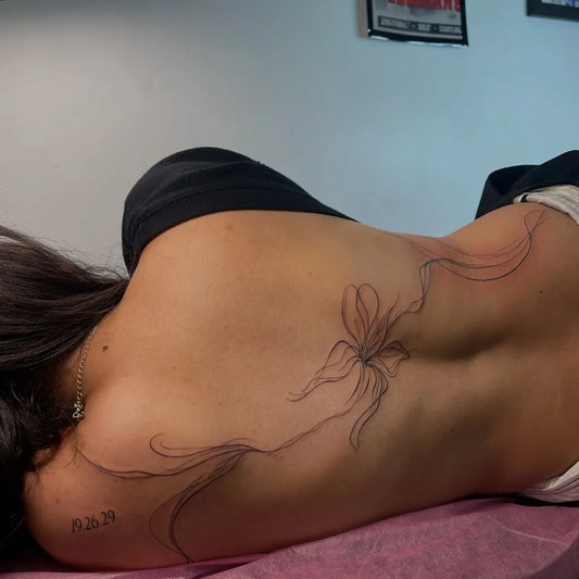 Small Linework Orchid on Women Back Tattoo by @yourcrush.tattoos