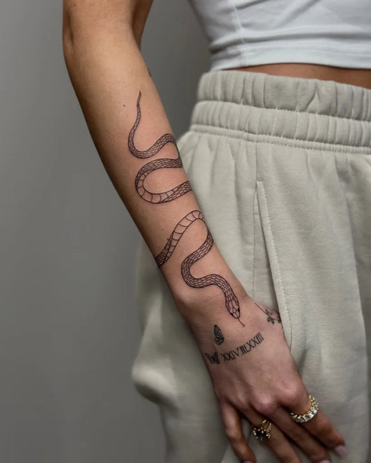 Small Linework Snake and Roman Numerals on Women Arm Tattoo by @nika_tatts