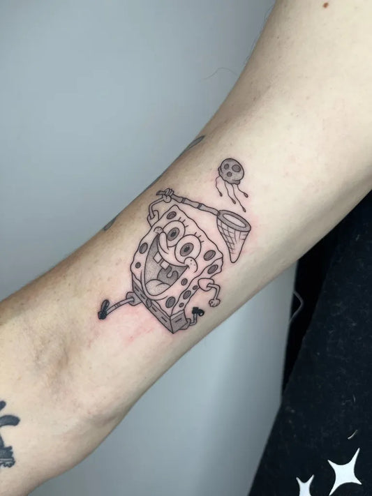 Small Linework Spongebob with Net Cartoon Tattoo on Women Arm by @zizusdrawing