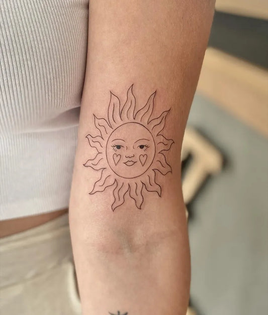 Small Linework Sun with face on Women Arm Tattoo by @ninasweeneytattoo