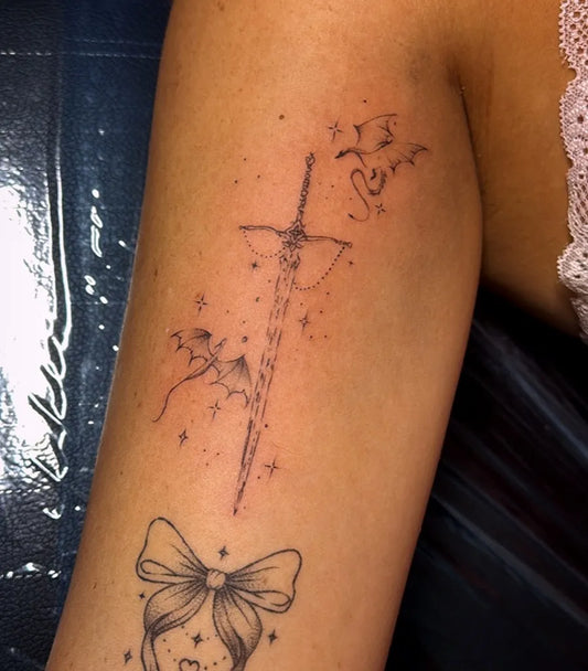 Small Linework Sword Bats Bow on Women Arm Tattoo by @inklore_mk