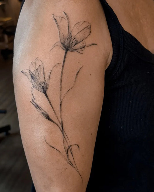 Small Linework Tulips Nature Tattoo on Women Arm by @lukas.ejsmont