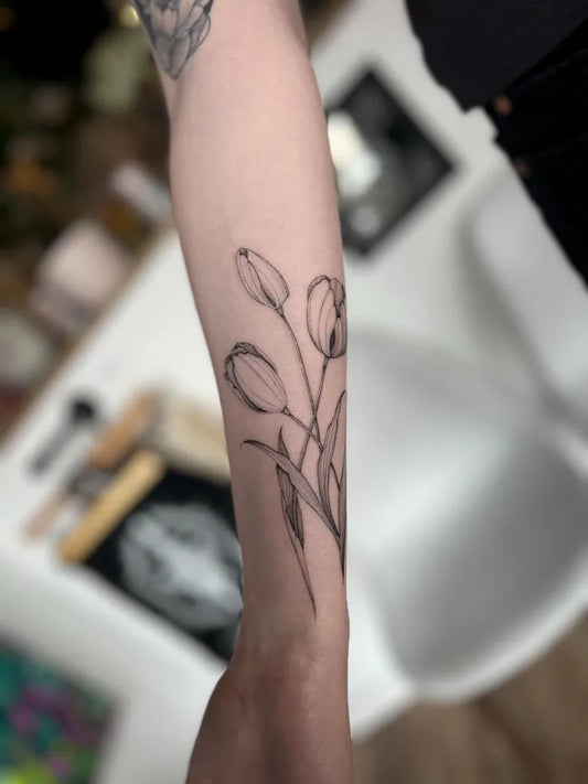 Small Linework Tulips Tattoo on Women Arm by @finelinebaddie