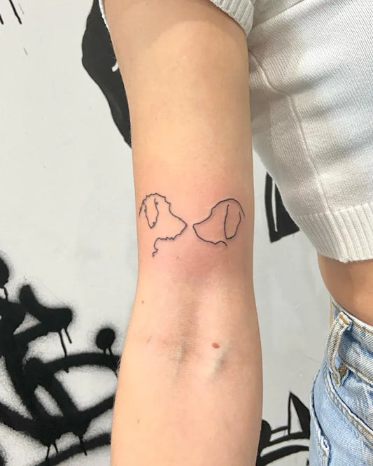 Small Linework Two Dog Heads on Women Arm Tattoo by @missjadeink