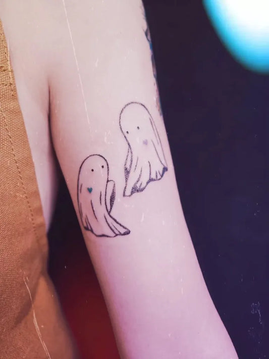 Small Linework Two Ghosts Tattoo on Women Arm by @chingwa.tw