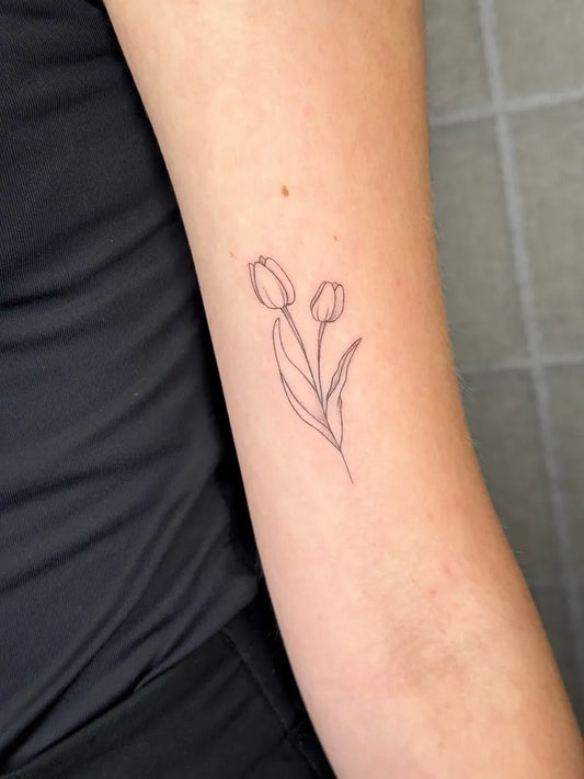 Small Linework Two Tulips Tattoo on Women Arm by @anyz.tattoo