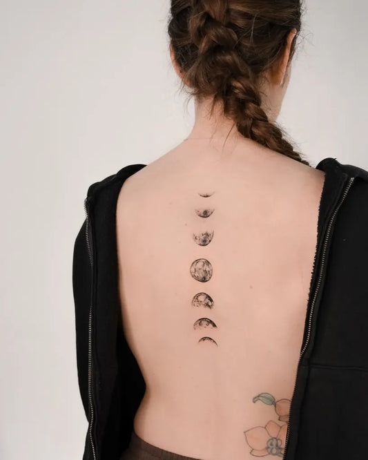 Small Lunar Phases on Women Spine Tattoo by @cherie.ink