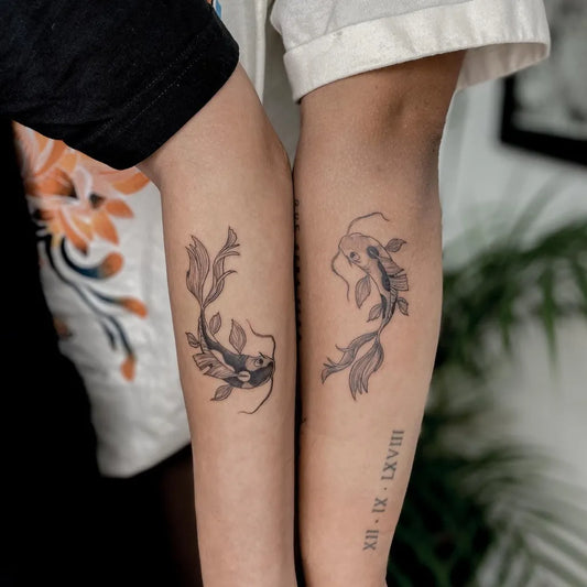 Small Matching Fine Line Yin Yang Koi Tattoo on Women Arm by @leroygiesbers