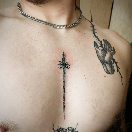 Small Medieval Sword and Hand on Men Sternum Tattoo by @opa.ink