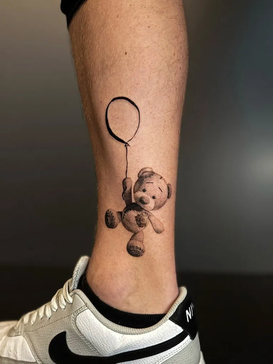 Small Micro Realism Bear with Balloon on Men Leg Tattoo by @andreasrahbek