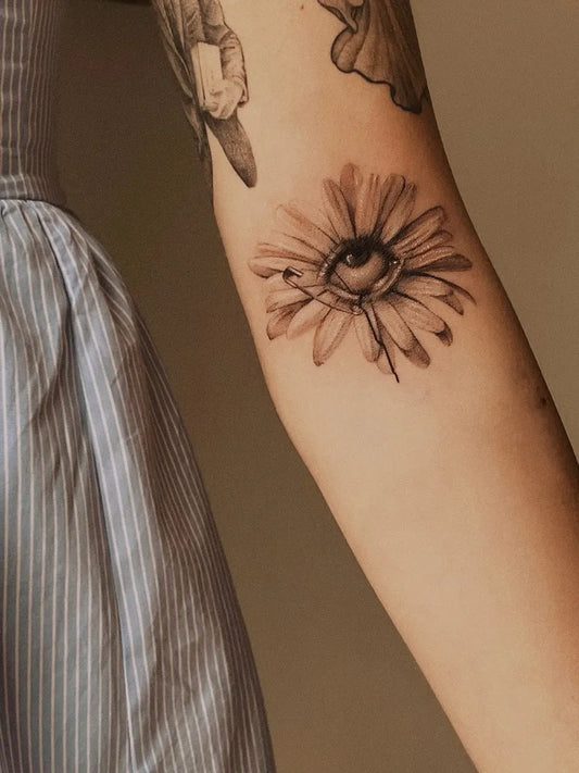 Small Micro Realism Daisy with Eye on Women Arm Tattoo by @_luisacirillo_