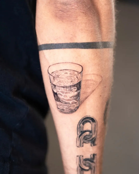 Small Micro Realism Glass of Water and Initials on Men Arm Tattoo by @miamariatattoo